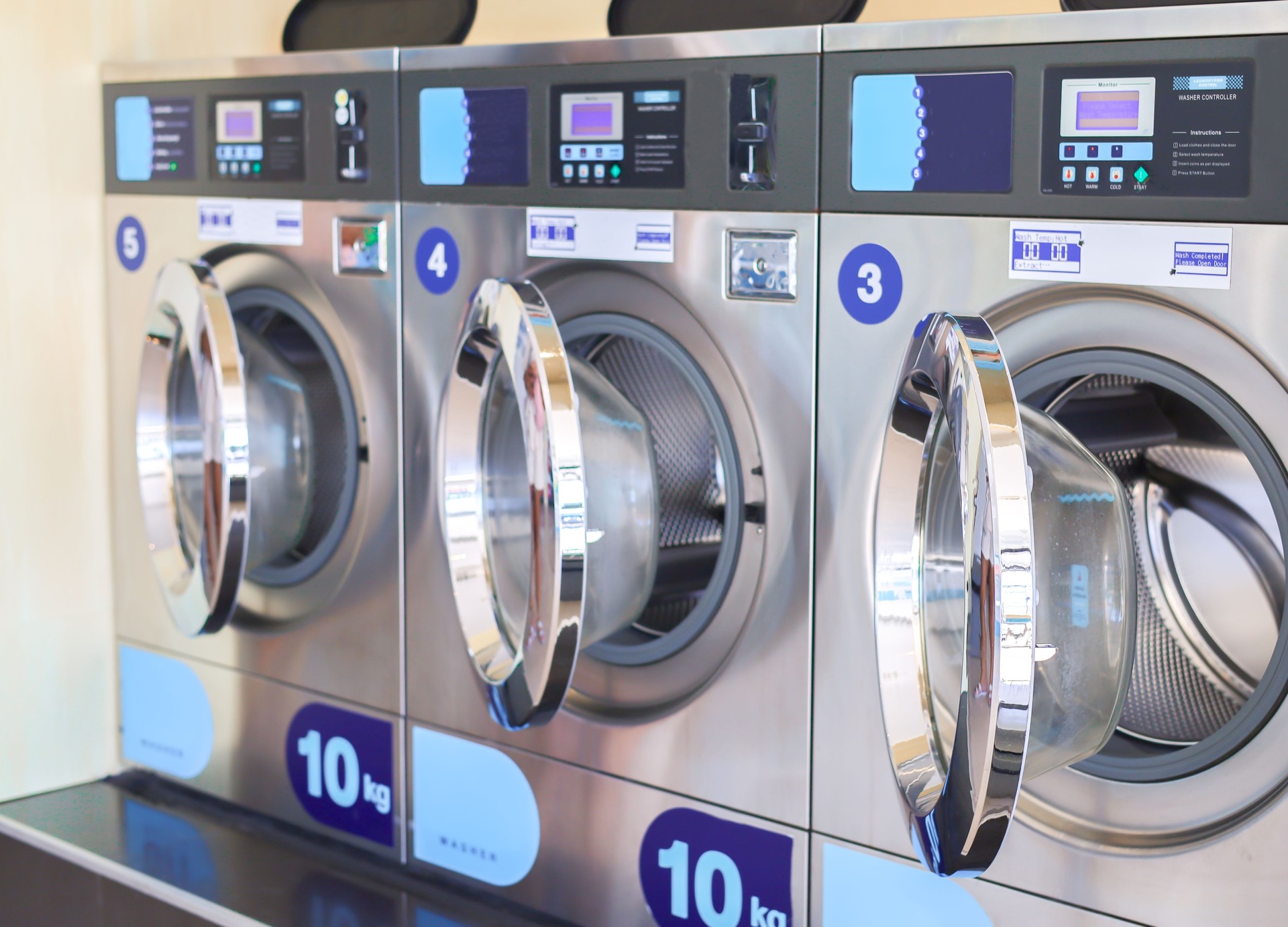 A lot of washing machine in a public laundromat. Laundromat. wash & dry shop. Industrial laundry machines. Self-service facility with many automatic washing machines. commercial laundry and drying.