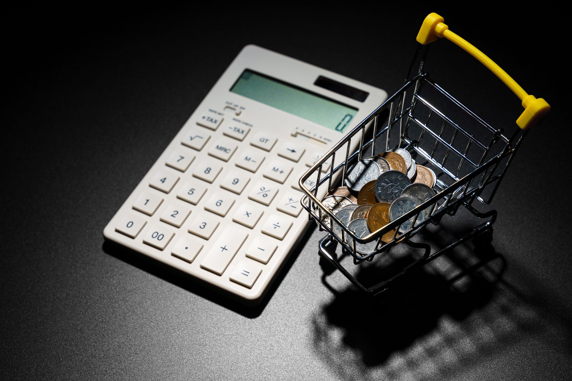 Calculator and coins on dark background